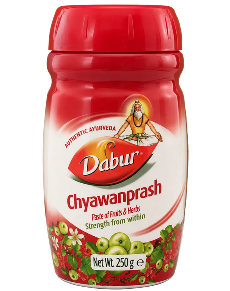 Red jar of Dabur Chyawanprash on a white surface with a brown cardboard background